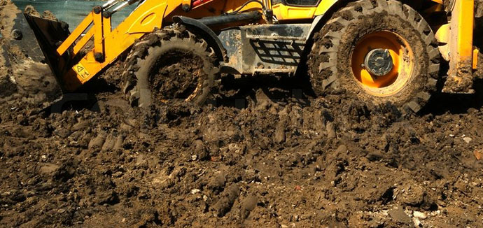 tractor en terreno húmedo levantando tierra